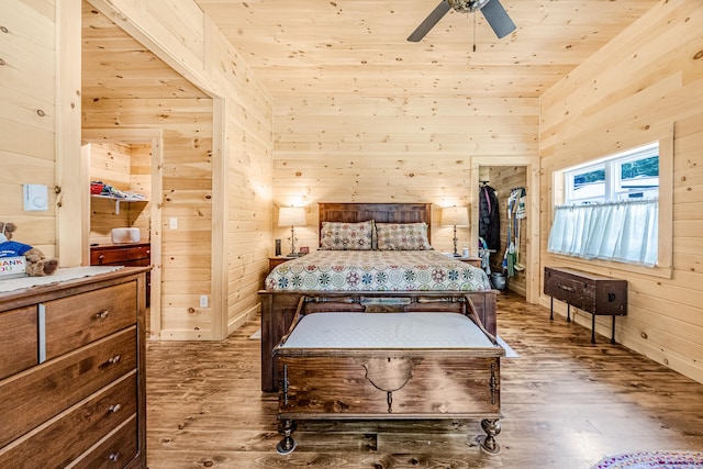 bedroom featuring wood ceiling, wooden walls, ceiling fan, and hardwood / wood-style flooring