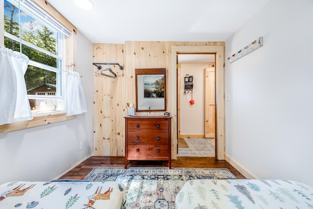 unfurnished bedroom featuring multiple windows and dark hardwood / wood-style floors