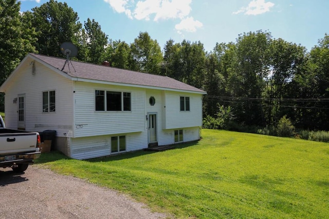 raised ranch with driveway and a front lawn