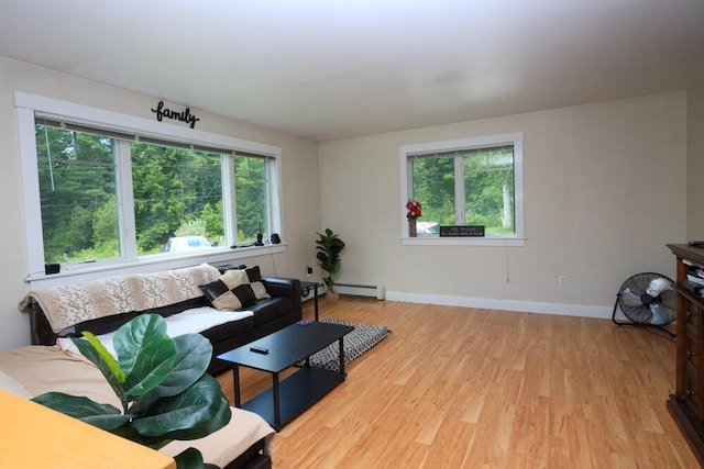 living room with plenty of natural light, light wood-type flooring, and a baseboard heating unit