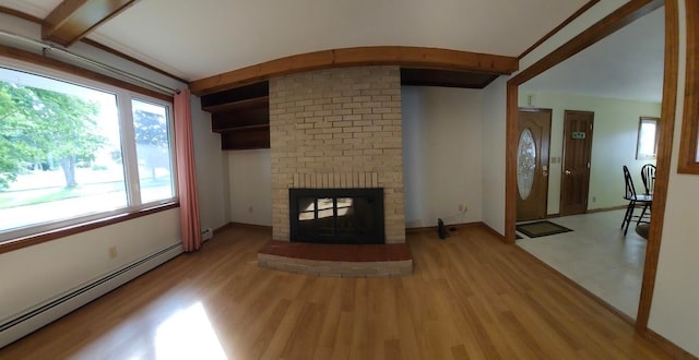 unfurnished living room with brick wall, light hardwood / wood-style floors, baseboard heating, and a brick fireplace