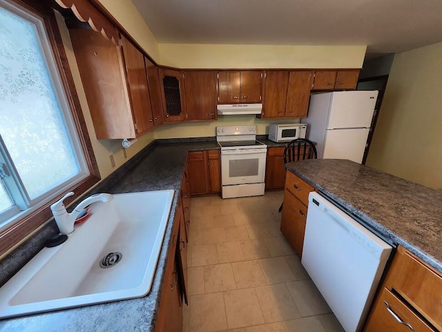 kitchen featuring sink, white appliances, and light tile patterned floors