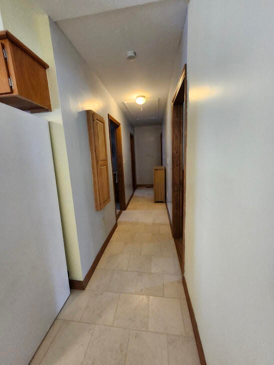 hall featuring light tile patterned flooring