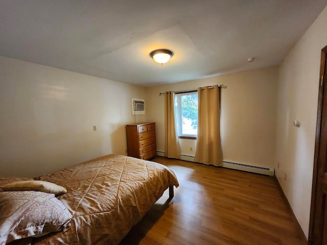 bedroom featuring a baseboard radiator, hardwood / wood-style flooring, and a wall mounted air conditioner