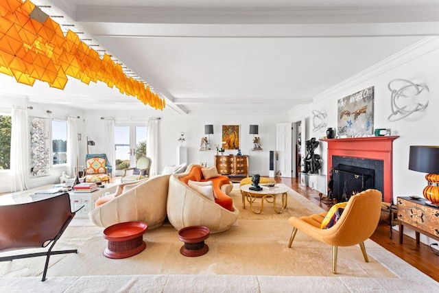 living room with beam ceiling, a fireplace, light wood-type flooring, and ornamental molding