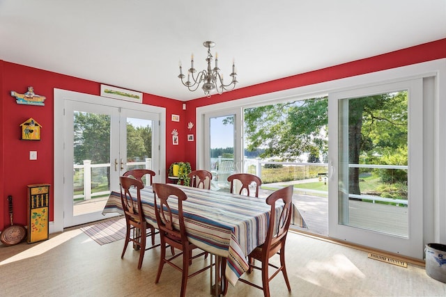 dining space featuring plenty of natural light, french doors, and a notable chandelier