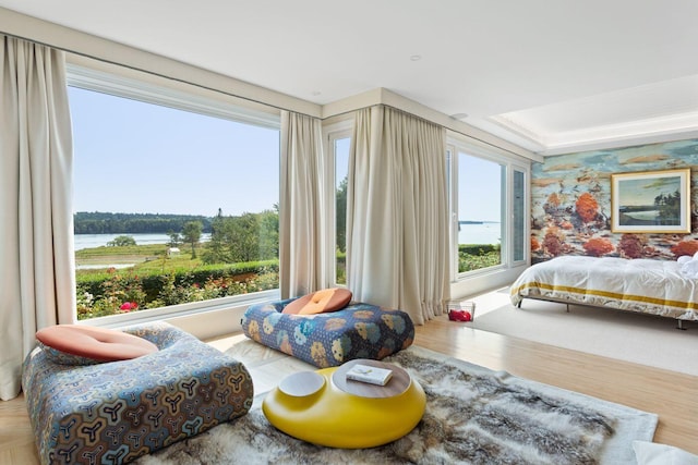 bedroom with a water view and hardwood / wood-style flooring