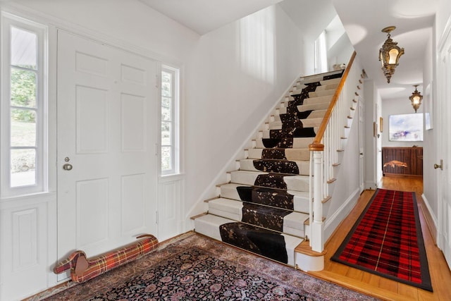 foyer entrance with a wealth of natural light and hardwood / wood-style floors