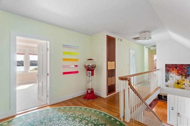 corridor with light hardwood / wood-style flooring and lofted ceiling