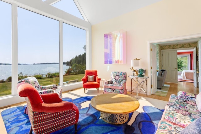 living room with a water view, lofted ceiling, and wood-type flooring