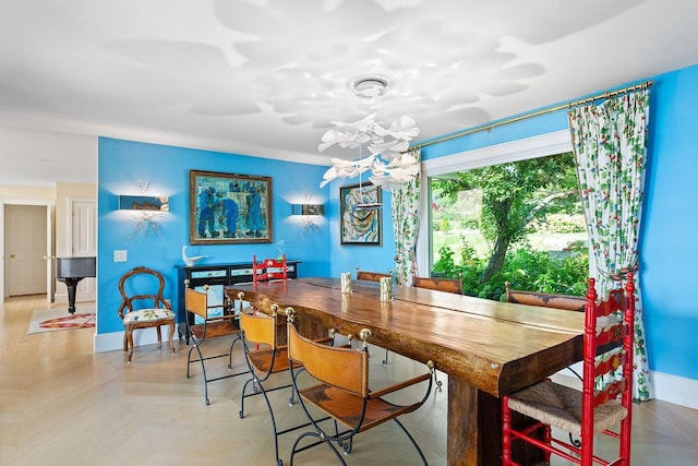 dining space featuring light parquet floors and a chandelier