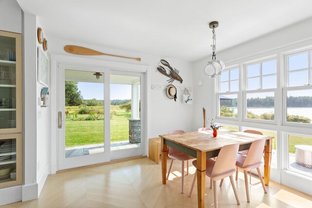 dining area with a water view and light parquet flooring