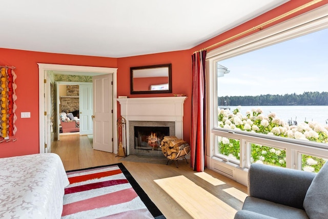 bedroom with a water view and light hardwood / wood-style flooring