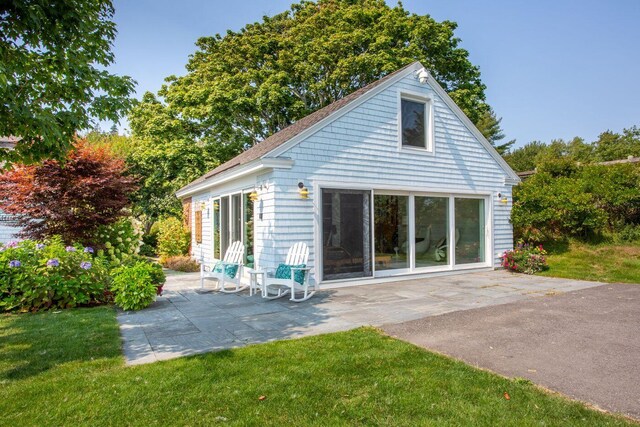 back of house with a patio area and a lawn