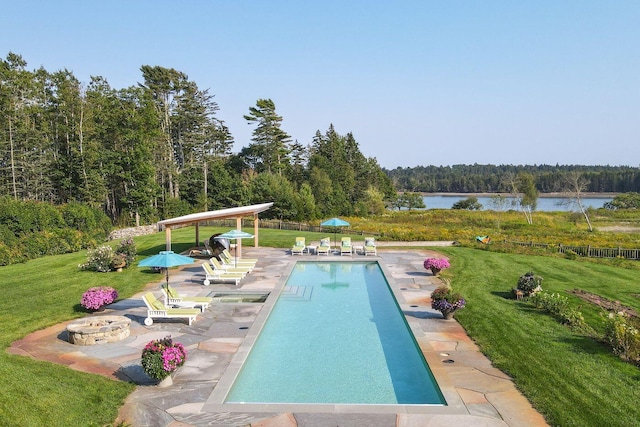 view of pool with a patio, a water view, and a yard