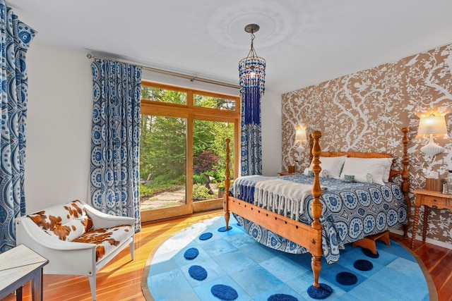 bedroom featuring an inviting chandelier and light wood-type flooring