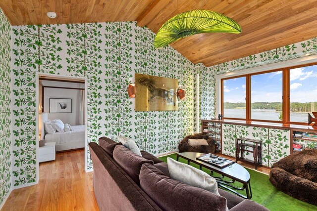 living room featuring light hardwood / wood-style flooring, a water view, wooden ceiling, and vaulted ceiling