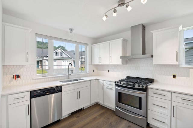 kitchen with wall chimney exhaust hood, sink, dark hardwood / wood-style floors, appliances with stainless steel finishes, and backsplash