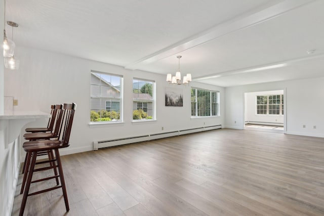 unfurnished living room with beamed ceiling, an inviting chandelier, light hardwood / wood-style flooring, and baseboard heating