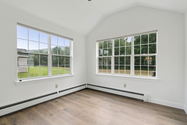 spare room with a healthy amount of sunlight, light hardwood / wood-style floors, and lofted ceiling