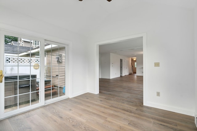 spare room featuring vaulted ceiling, ceiling fan, and hardwood / wood-style floors