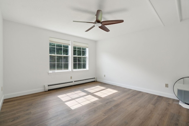 spare room featuring baseboard heating, ceiling fan, and hardwood / wood-style floors