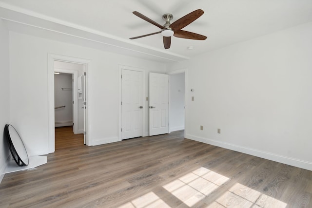 unfurnished bedroom featuring a baseboard heating unit, ceiling fan, and hardwood / wood-style floors