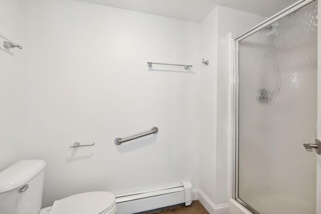 bathroom with toilet, baseboard heating, and an enclosed shower