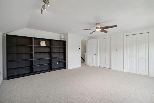 interior space featuring multiple closets, carpet, ceiling fan, and track lighting