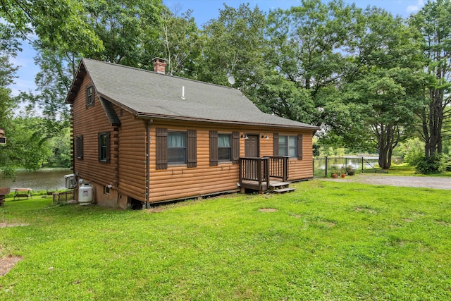 cabin with a water view and a front lawn