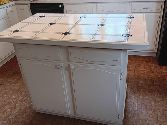 interior space with white cabinetry and dark parquet floors