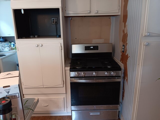 kitchen featuring washer / clothes dryer, stainless steel gas stove, and white cabinets