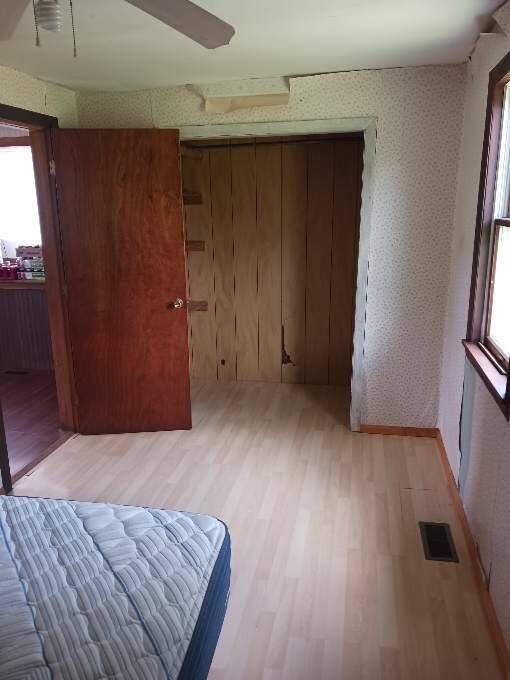 unfurnished bedroom featuring hardwood / wood-style flooring and ceiling fan