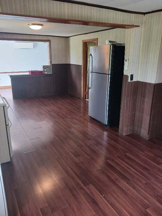 spare room featuring an AC wall unit and dark hardwood / wood-style floors