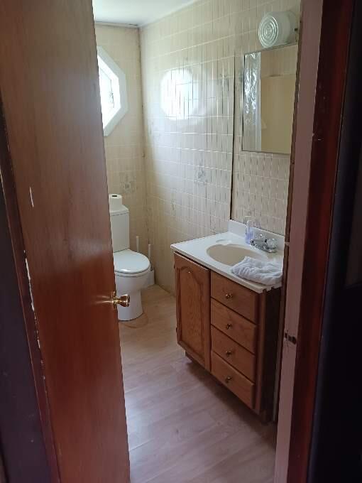 bathroom with hardwood / wood-style flooring, vanity, toilet, and tile walls