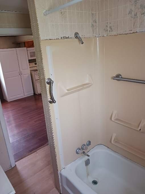 bathroom with shower / tub combination and hardwood / wood-style flooring