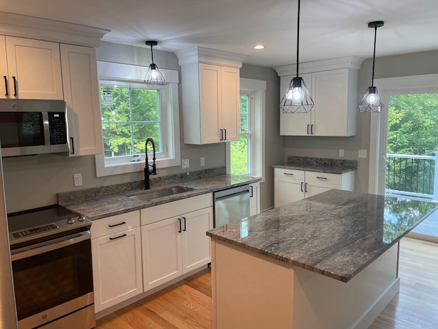 kitchen featuring sink, white cabinetry, stainless steel appliances, and light hardwood / wood-style floors