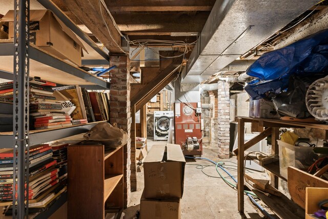 basement featuring brick wall and washer / clothes dryer