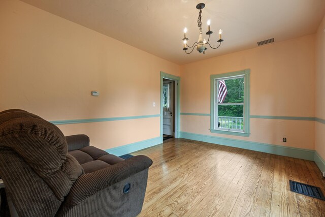 living room with light hardwood / wood-style floors and a chandelier