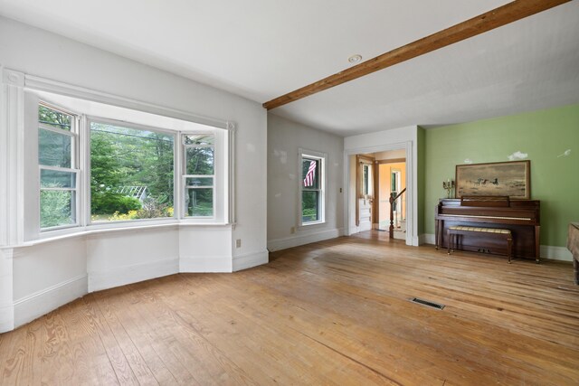 interior space featuring beamed ceiling and light hardwood / wood-style flooring