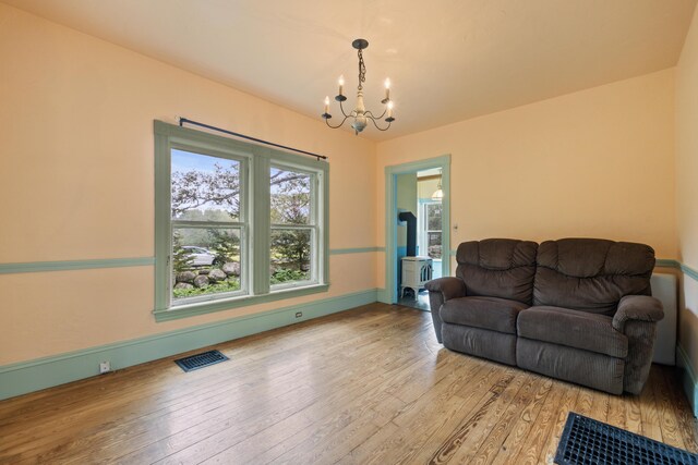 living room with a notable chandelier and light hardwood / wood-style flooring