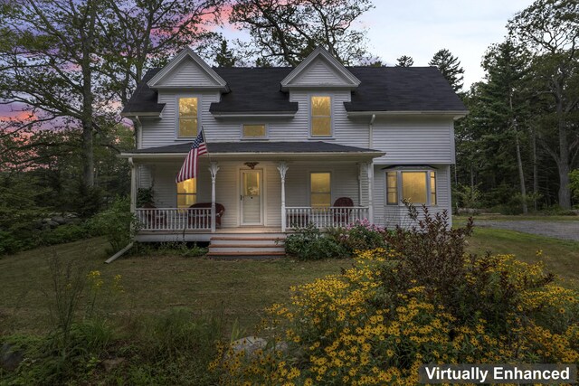 view of front of house with a porch and a yard