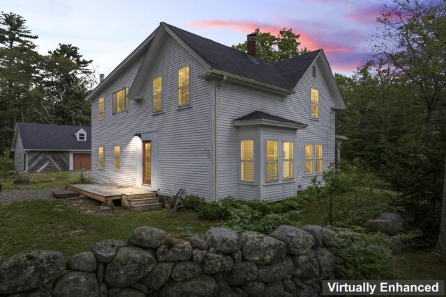 back house at dusk featuring a deck