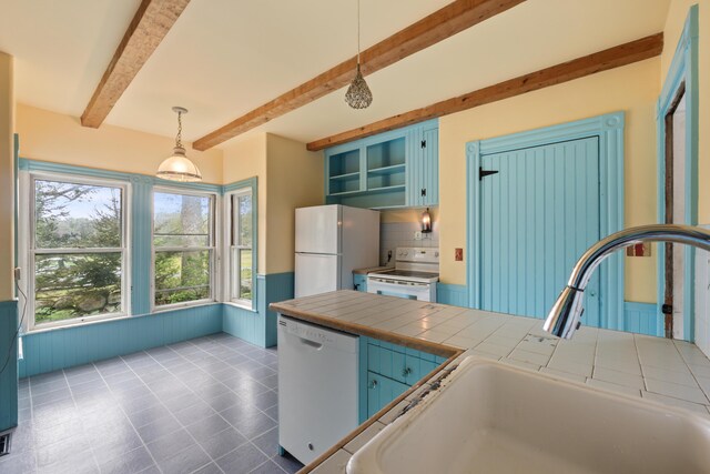 kitchen featuring decorative light fixtures, tile patterned floors, white appliances, beam ceiling, and tile countertops