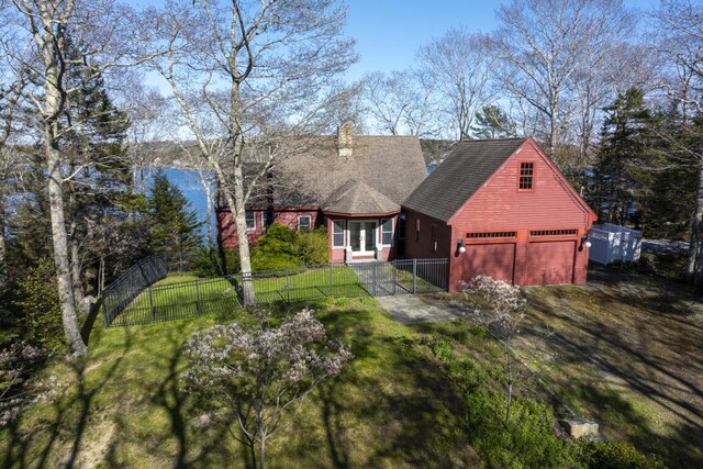 exterior space with a garage and a lawn