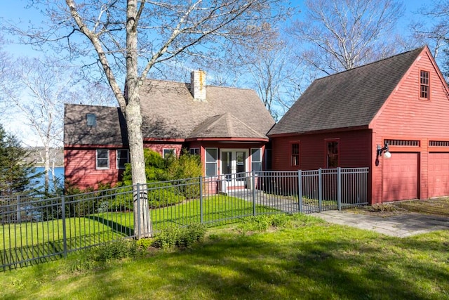 back of property with a garage and a lawn