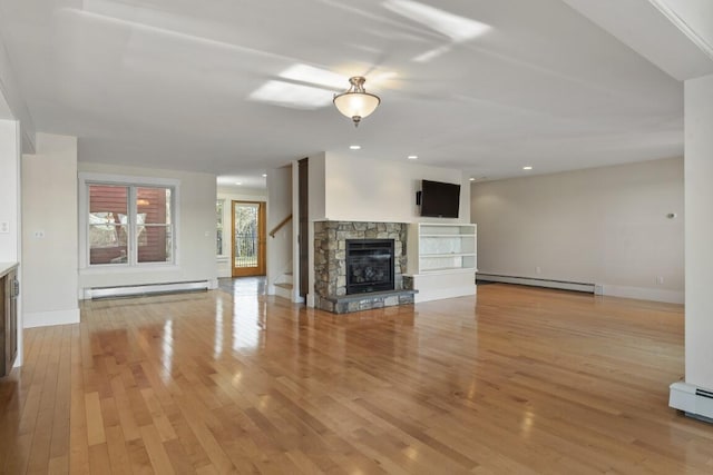 unfurnished living room featuring a stone fireplace, light wood-type flooring, and baseboard heating