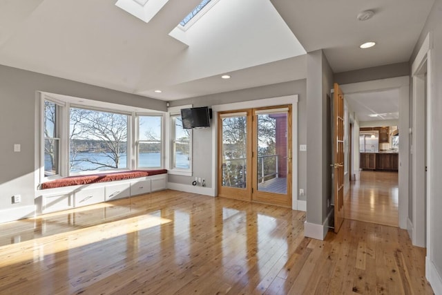 workout room featuring light hardwood / wood-style flooring and a skylight