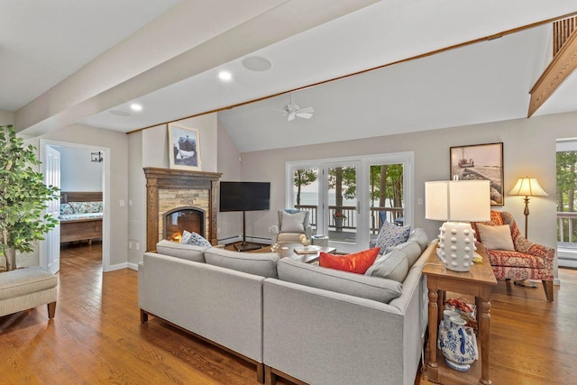 living room featuring lofted ceiling with beams, a fireplace, ceiling fan, and wood-type flooring