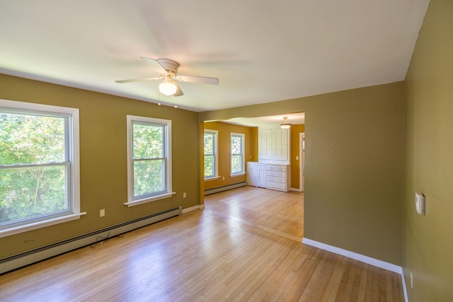 empty room with a baseboard radiator, ceiling fan, and light wood-type flooring